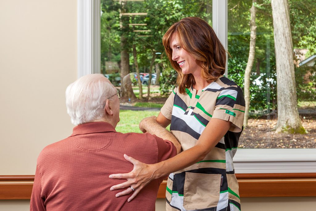 at-home-faq A personal care aide assists a patient with flexibility exercises